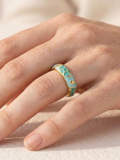 Main portant une bague émaillée