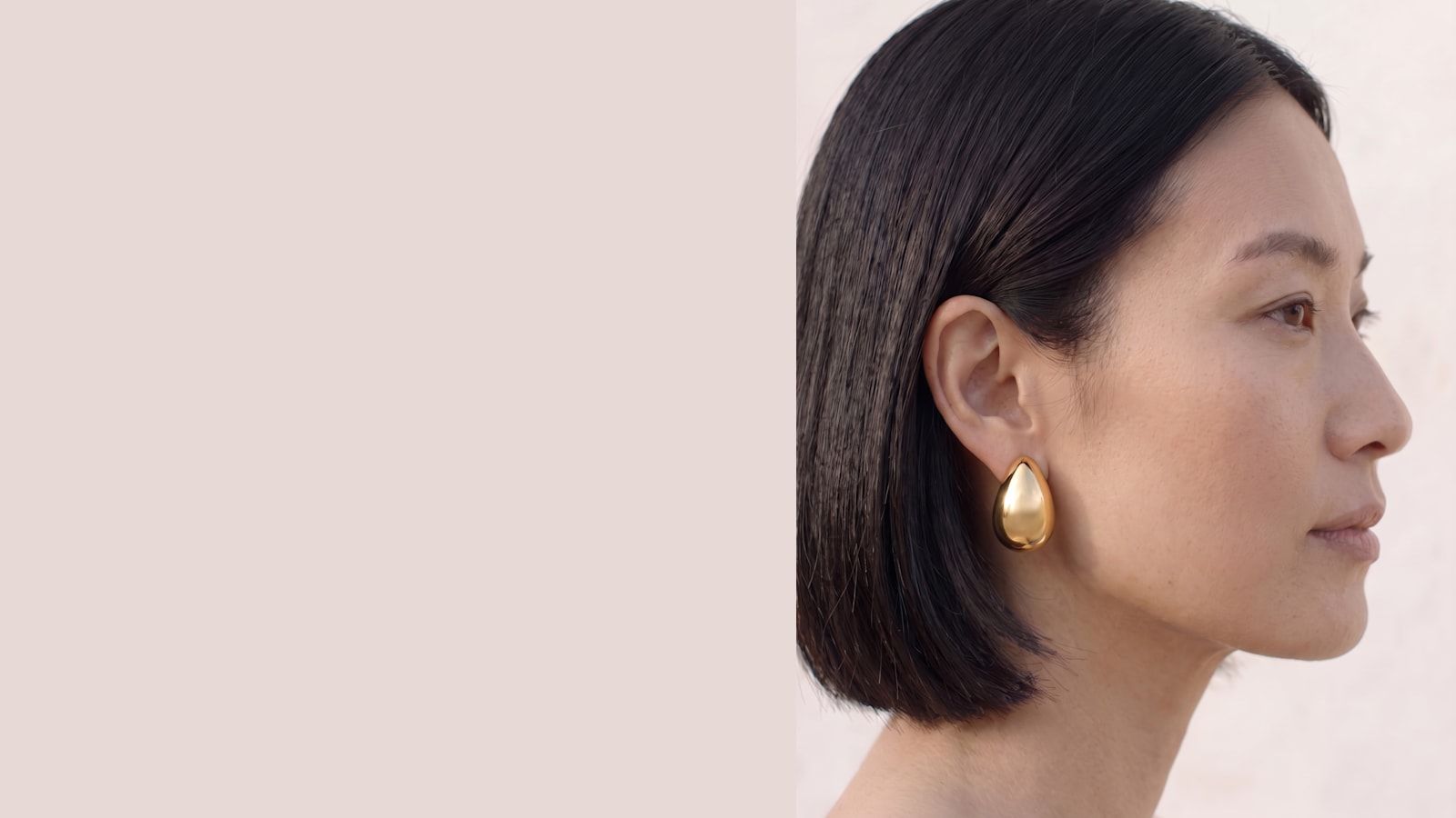 Profil portant une boucle d'oreille fleur dorée