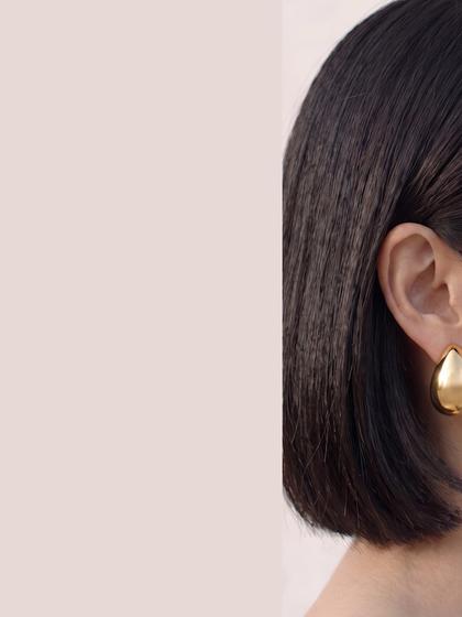 Profil portant une boucle d'oreille fleur dorée