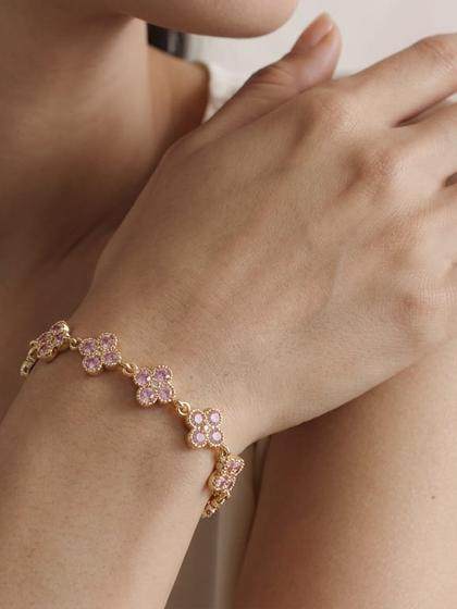Poignet portant un bracelet à fleurs de zircons roses